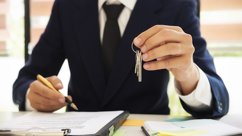 Un agent immobilier rédige un contrat de bail et encaisse le dépôt de garantie