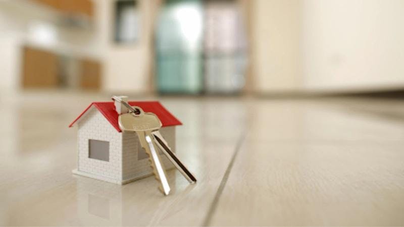 maison miniature avec des clés posées dessus. 